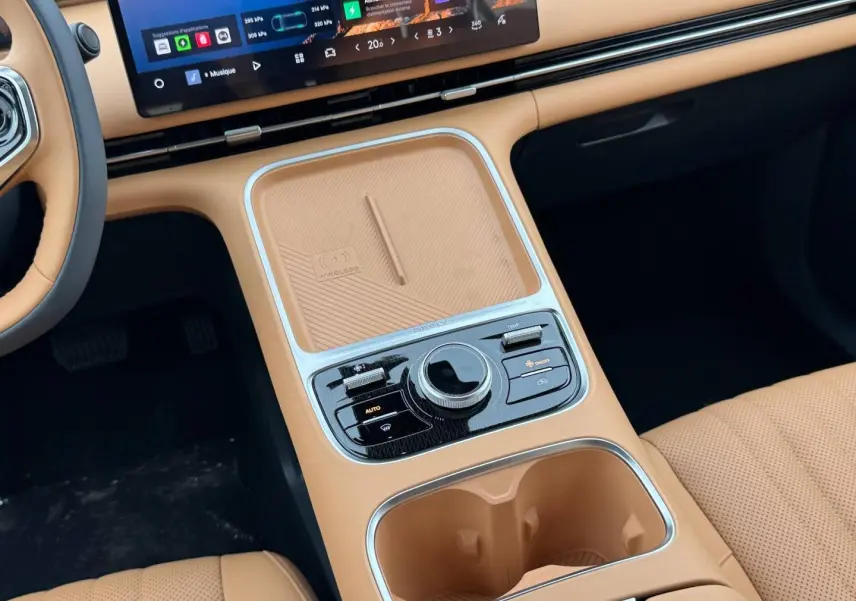 Vue rapprochée de la console centrale beige du Geely STARRAY 1.5 EM-i avec écran tactile et commandes de climatisation.