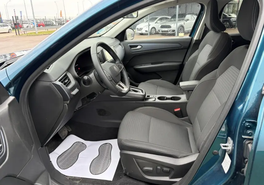 Vue intérieure côté conducteur de la Renault Arkana 2025 bleu Zanzibar, sièges gris et volant textile grainé.