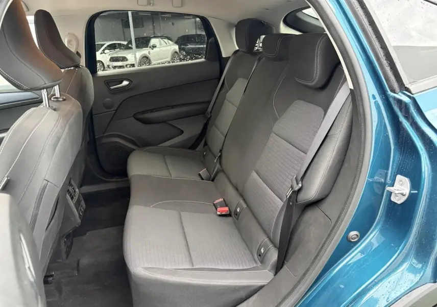 Vue intérieure arrière côté droit du Renault Arkana 2025 bleu Zanzibar, montrant la banquette noire et les portières.