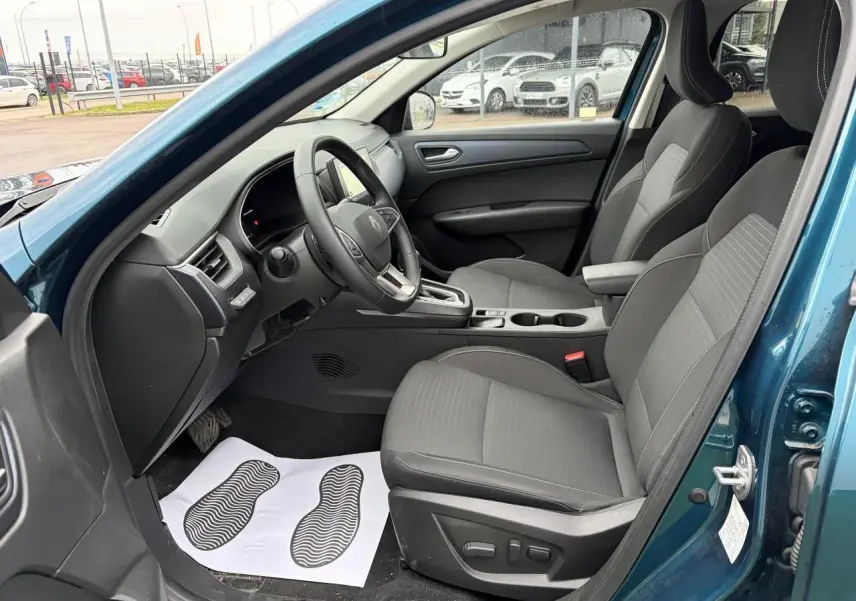 Vue intérieure côté conducteur de la Renault Arkana bleu Zanzibar, sièges gris avec réglages électriques visibles.