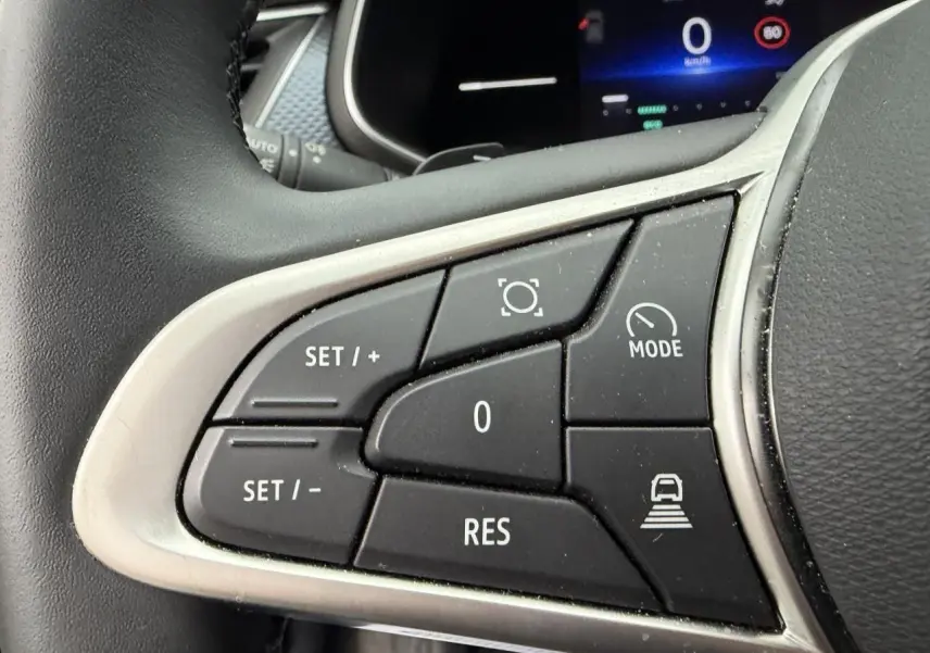 Gros plan sur les commandes au volant gauche du Renault Arkana 2025, finition noire avec contour argenté.