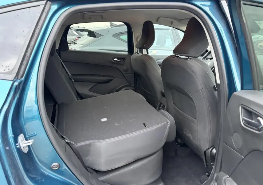 Vue intérieure côté gauche arrière du Renault Arkana bleu Zanzibar avec banquette arrière rabattue vers l'avant.