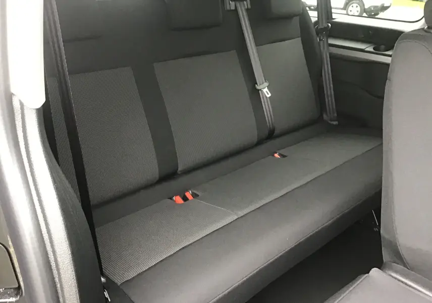 Vue intérieure du siège arrière en tissu gris foncé du FIAT Scudo Combi XL 9 places, avec ceintures de sécurité visibles.