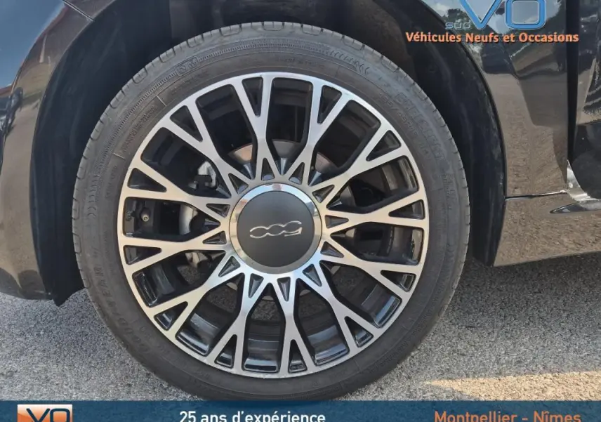 Gros plan sur la jante alliage 15 pouces noire et argentée du côté gauche d'une FIAT 500C noire 2024.