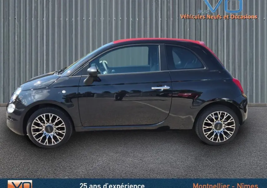Profil côté gauche d'une FIAT 500C noire 2024 avec jantes alliage 15 pouces, toit rouge et finition pack confort.