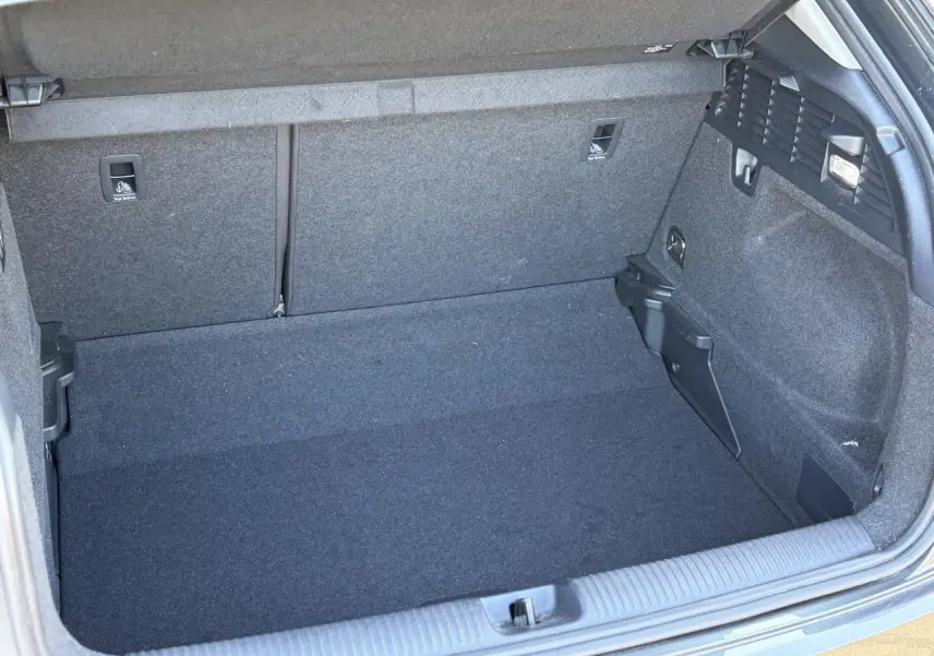 Coffre ouvert vu de face d’un Audi Q2 35 TFSI S-Line 2024, intérieur de coffre gris foncé sans chargement visible.