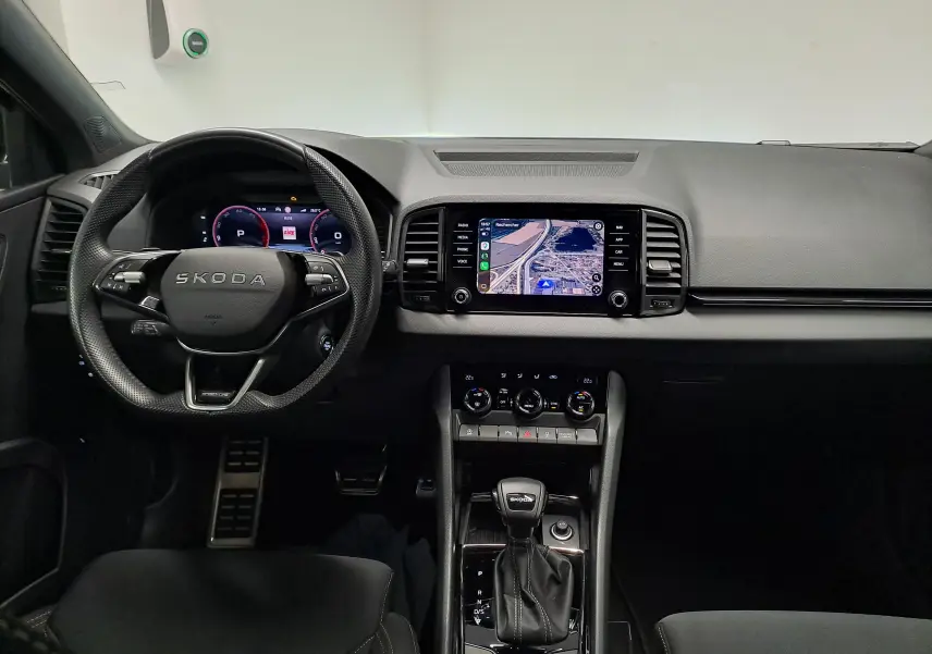 Vue intérieure frontale du tableau de bord du Skoda Karoq gris graphite avec écran tactile et volant multifonction.