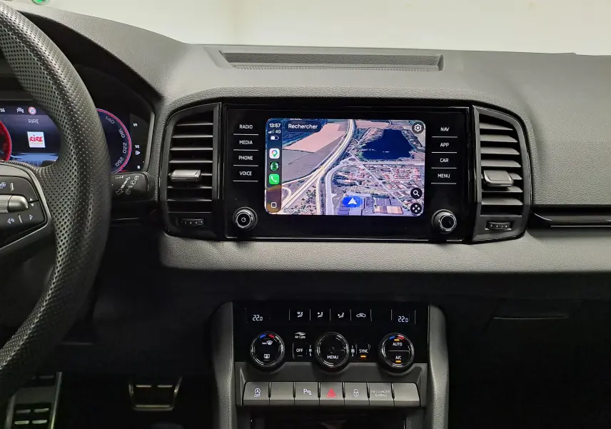 Vue intérieure centrée sur la console centrale du Skoda Karoq 2025 avec écran tactile et commandes climatisation.
