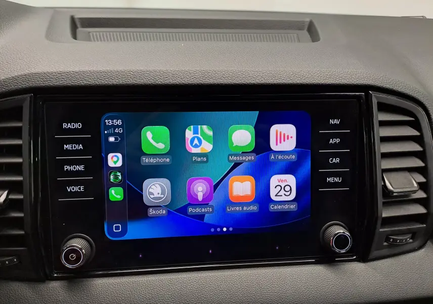 Écran tactile central du Skoda Karoq 2.0 TDI 150 DSG7 Sportline affichant Apple CarPlay, entouré de commandes noires.