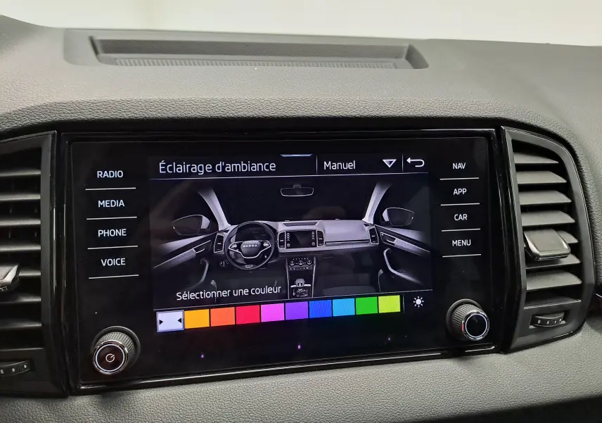 Écran tactile central du Skoda Karoq 2025 affichant le réglage manuel de l’éclairage d’ambiance avec palette de couleurs.