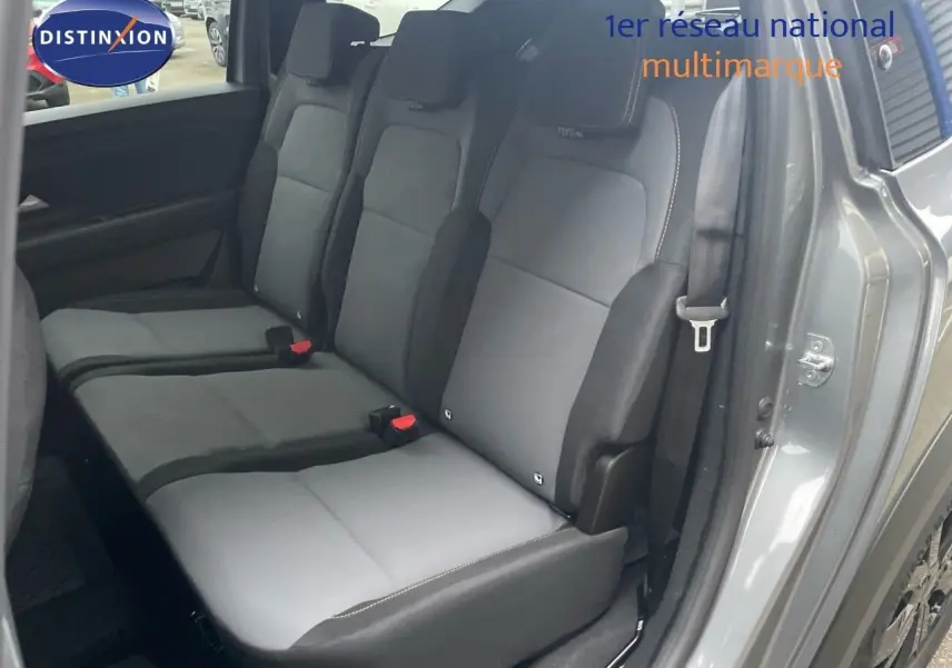 Vue latérale des sièges arrière gris foncé et clair du Dacia Jogger 2026, porte arrière ouverte, intérieur spacieux visible.