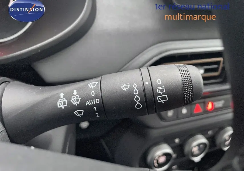 Gros plan sur la commande d’essuie-glace à gauche du volant dans l’habitacle sombre du Dacia Jogger gris schiste.