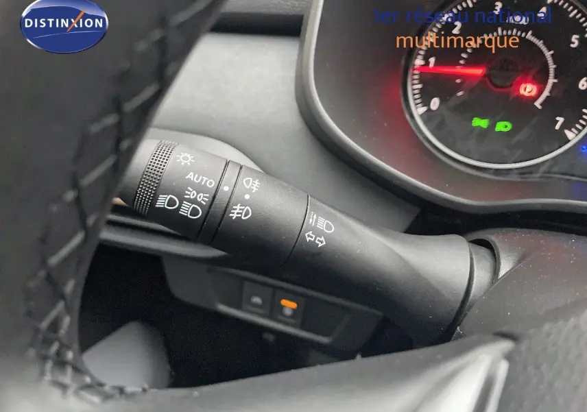 Gros plan sur la manette de clignotants et phares du tableau de bord d’un Dacia Jogger gris schiste métal.