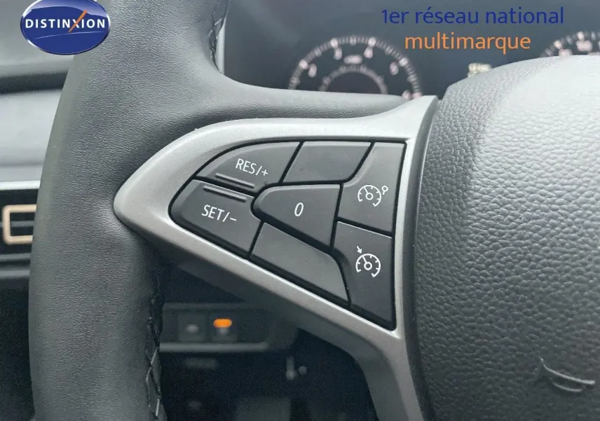 Gros plan sur les commandes de régulateur de vitesse au volant d’un Dacia Jogger gris schiste métal, intérieur noir.