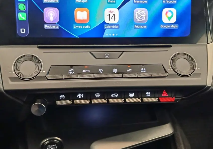 Vue rapprochée du tableau de bord central de la Peugeot 308 2023, avec écran tactile et commandes climatisation digitales.
