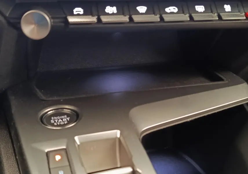 Détail intérieur de la console centrale noire de la Peugeot 308 2023 avec bouton démarrage et commandes tactiles.