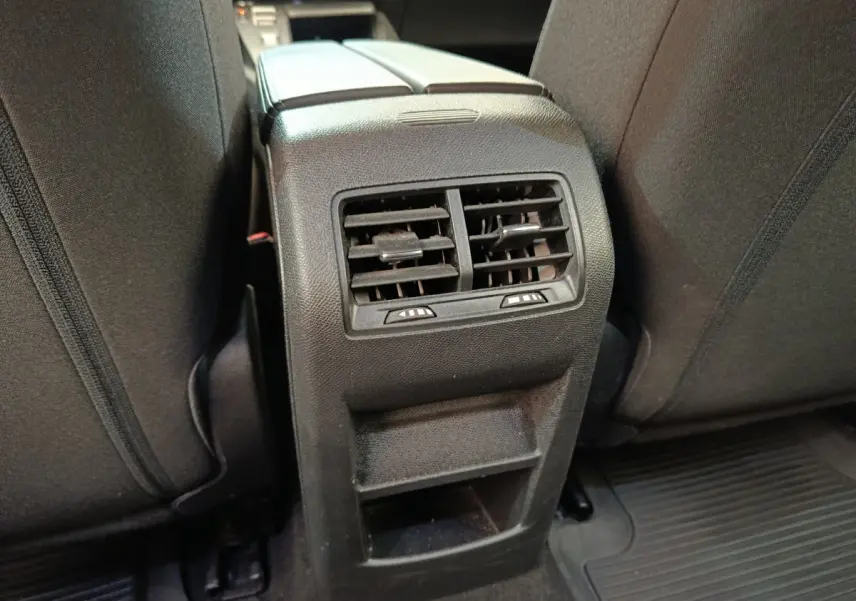 Gros plan sur la console arrière noire avec bouches d’aération et rangement entre les sièges arrière noirs du Peugeot 308 2023.
