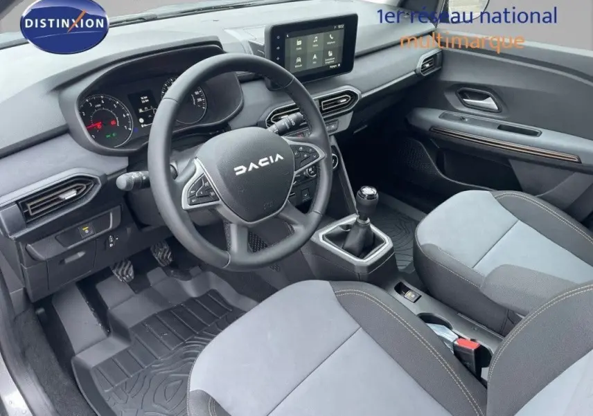 Vue intérieure côté conducteur de la Dacia Sandero Stepway 2025, tableau de bord gris avec écran tactile et volant multifonction.