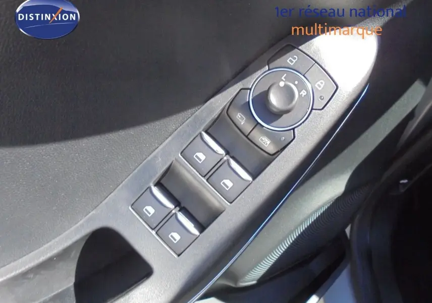 Gros plan sur les commandes des vitres et rétroviseurs côté conducteur d'une Ford Puma gris Solar Metal.