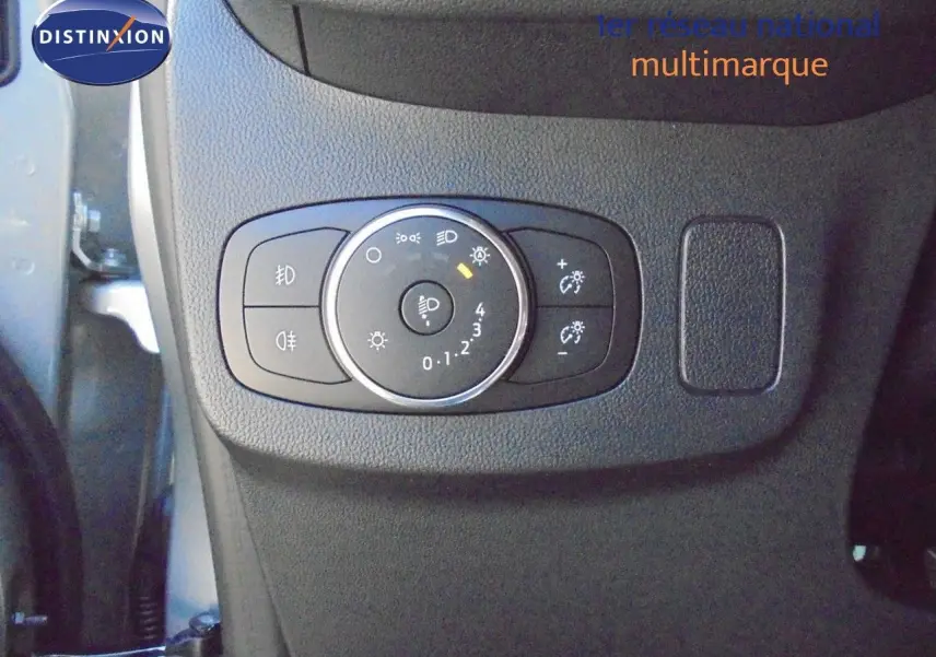 Gros plan sur le panneau de commande des phares à gauche du volant dans une Ford Puma gris Solar Metal 2022.