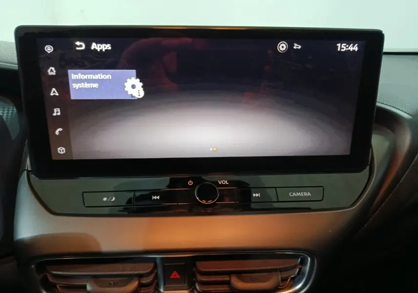 Écran tactile central allumé du Nissan Juke gris foncé, vue rapprochée du tableau de bord intérieur.