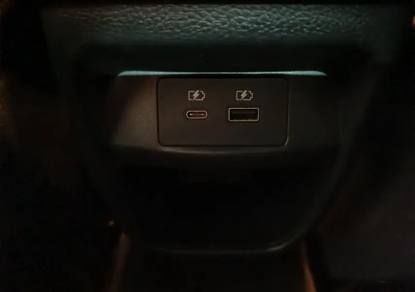 Gros plan sur les ports USB-C et USB-A pour recharge dans l'habitacle du Nissan Juke gris foncé 2025.