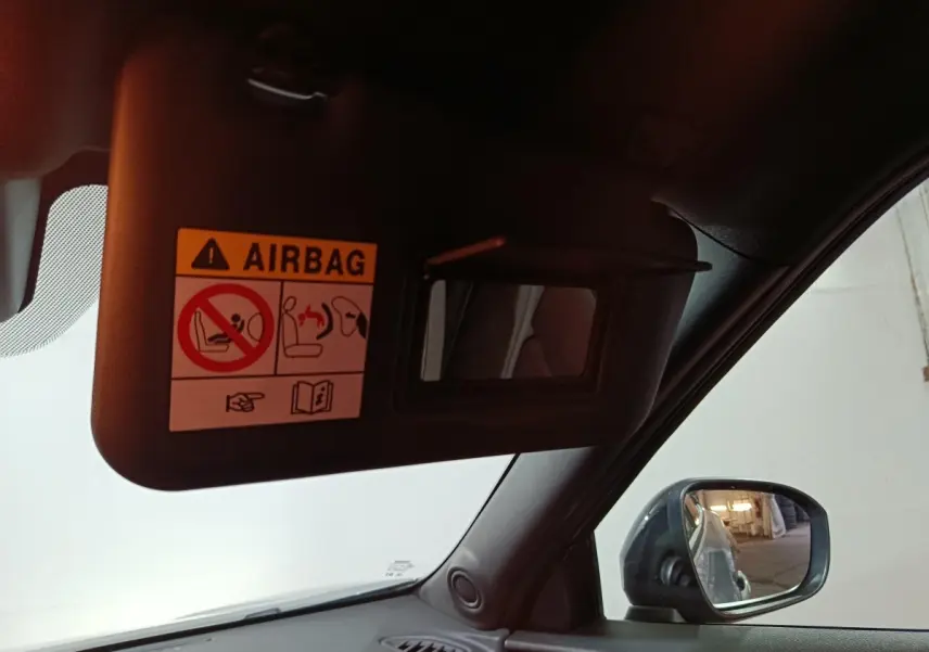 Intérieur Nissan Juke 2025, vue côté conducteur sur pare-soleil avec miroir et rétroviseur extérieur noir.