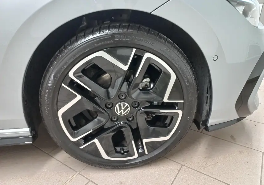 Gros plan sur la roue avant droite de la Volkswagen Golf 1.5 eTSI 150 R-Line argent dolomite avec jante noire et argentée.