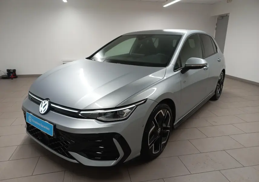 Volkswagen Golf 1.5 eTSI R-Line argent dolomite vue 3/4 avant en intérieur avec jantes noires distinctives.