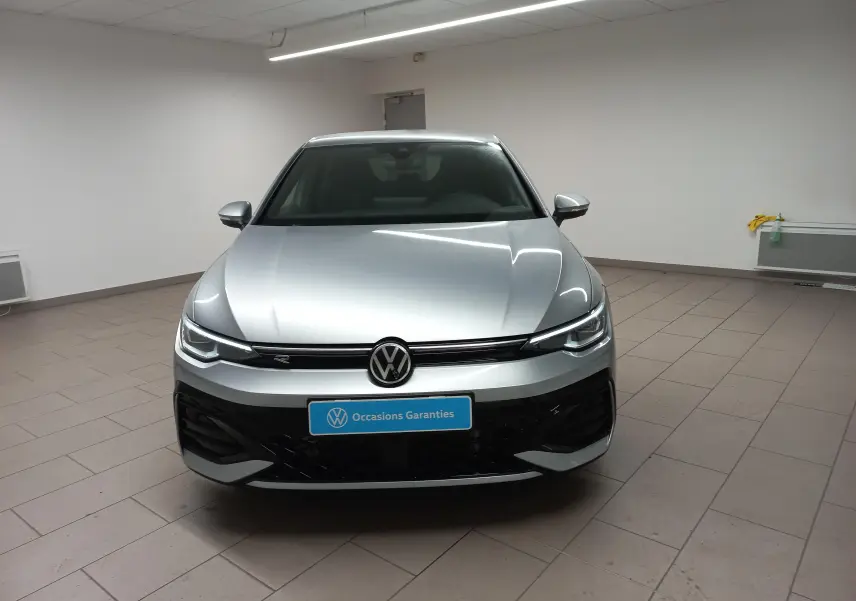 Vue frontale d'une Volkswagen Golf 1.5 eTSI R-Line Edition 2025 en argent dolomite, avec calandre noire et logo VW central.