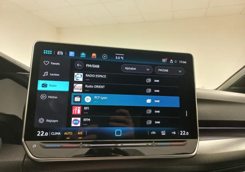 Écran tactile central de la Volkswagen Golf 1.5 eTSI R-Line 2025 affichant les options radio et la climatisation à 22°C.