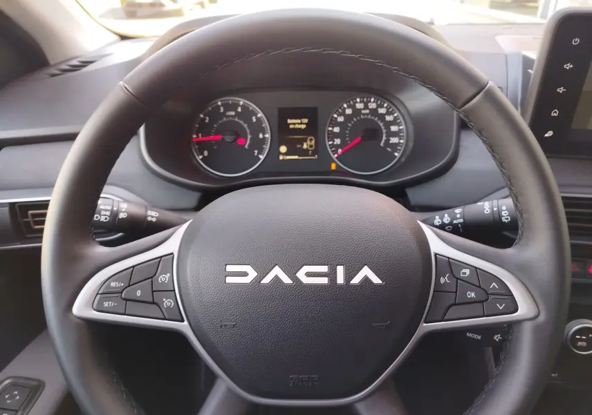 Vue rapprochée du volant noir de la Dacia Jogger 2026 avec commandes intégrées et tableau de bord numérique.