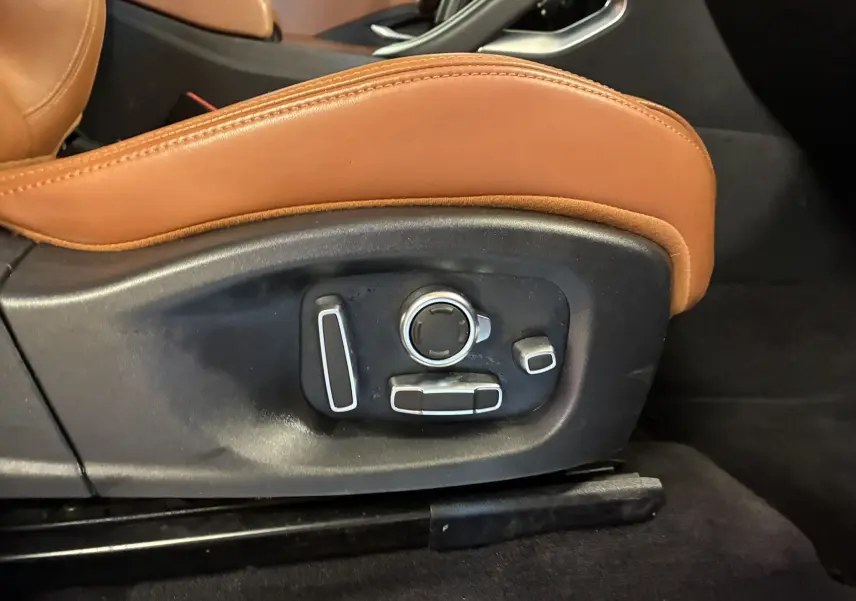 Détail des commandes de réglage électrique du siège en cuir brun dans une Jaguar E-PACE 2019.