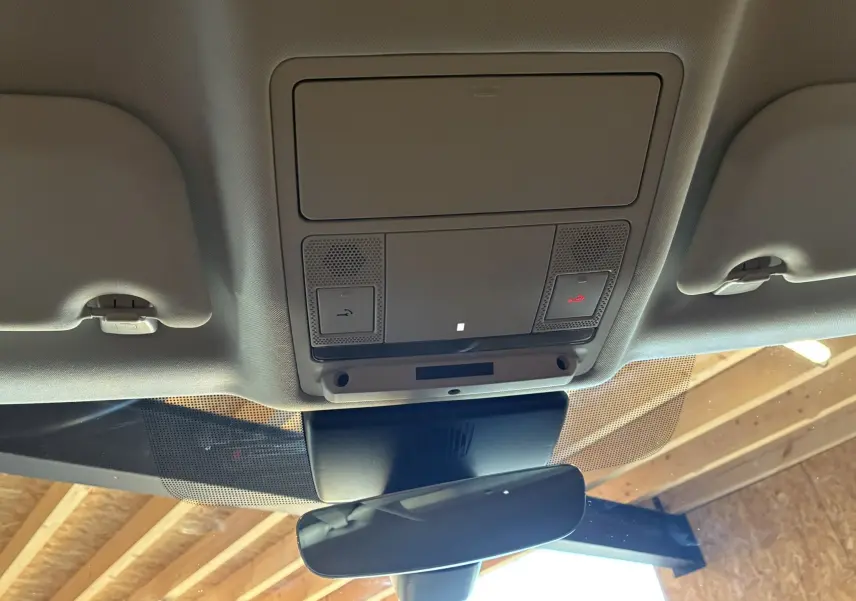 Vue intérieure du plafond avant du Jaguar E-PACE blanc 2019, avec commandes d'éclairage et rétroviseur central.