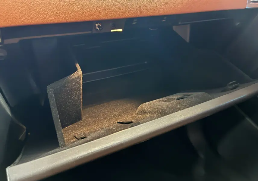 Gros plan sur la boîte à gants ouverte avec intérieur noir et tableau de bord en cuir brun du Jaguar E-PACE 2019.