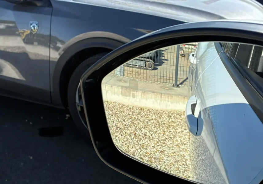 Rétroviseur extérieur droit montrant la porte blanche et la poignée du Jaguar E-PACE 2.0D 180 R-DYNAMIC HSE de 2019.