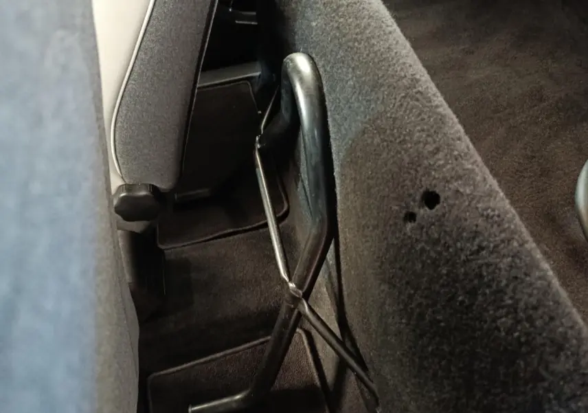 Détail de la banquette arrière rabattue avec mécanisme de levage visible dans l’habitacle d’une Renault ZOE blanche.
