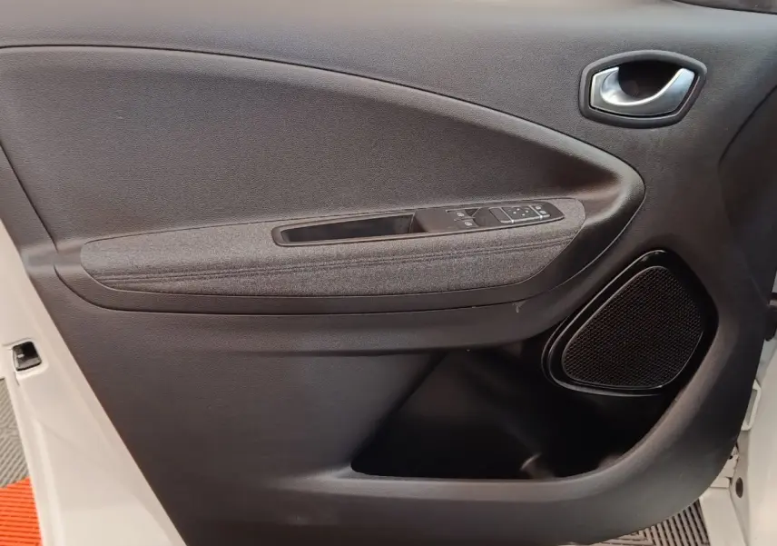Porte intérieure côté conducteur de Renault ZOE blanc 2021, avec commandes électriques et haut-parleur intégré.