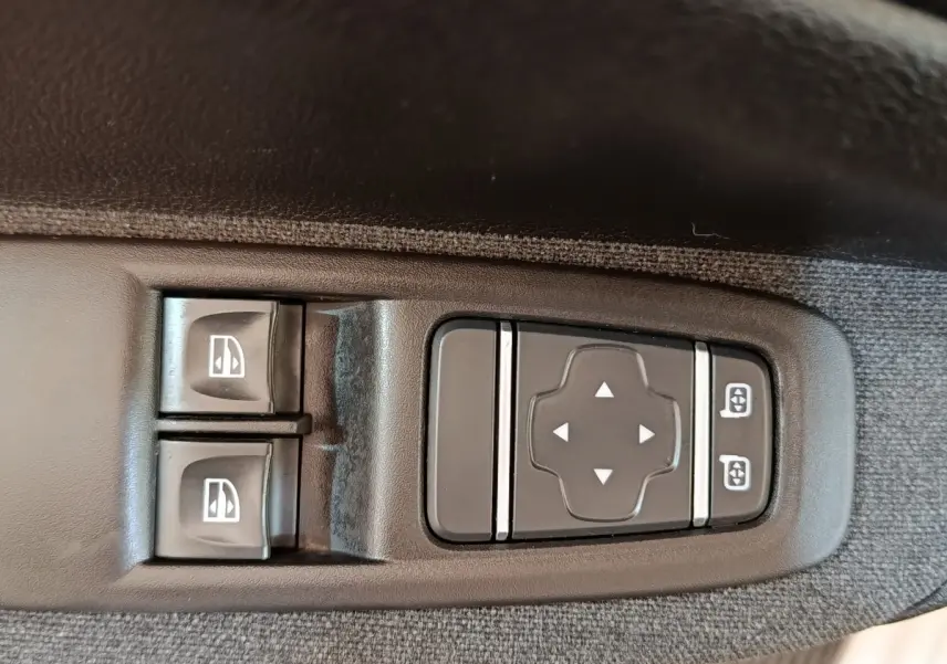 Gros plan sur les commandes de lève-vitres et réglage des rétroviseurs côté conducteur de la Renault ZOE blanche Zen R135 2021.
