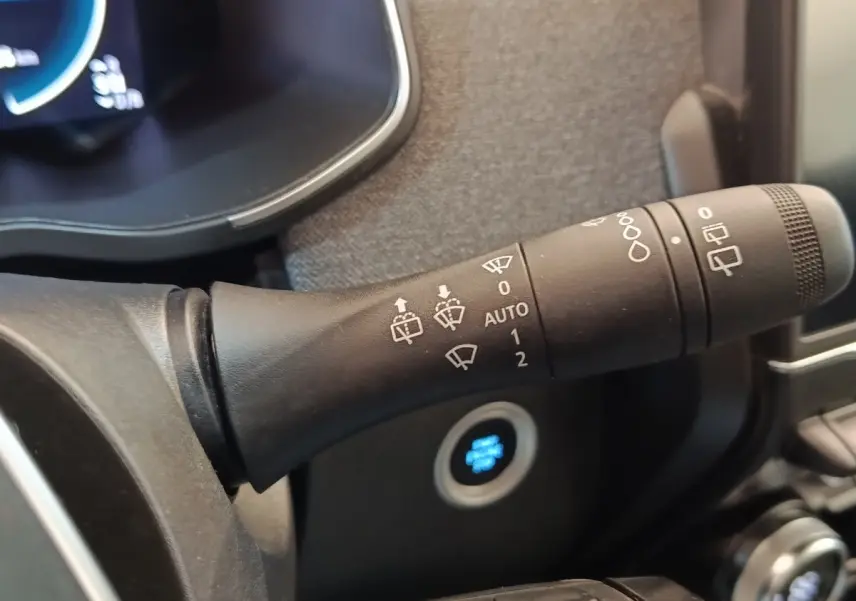 Gros plan sur la commande d’essuie-glace à gauche du volant dans l’habitacle blanc de la Renault ZOE Zen R135 2021.