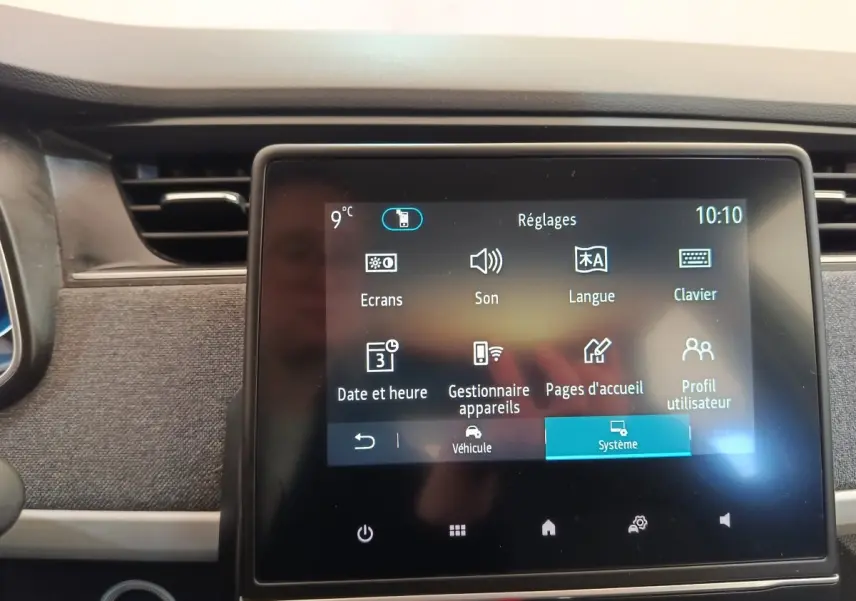 Écran tactile central affichant le menu réglages dans l’habitacle d’une Renault ZOE blanche de 2021.