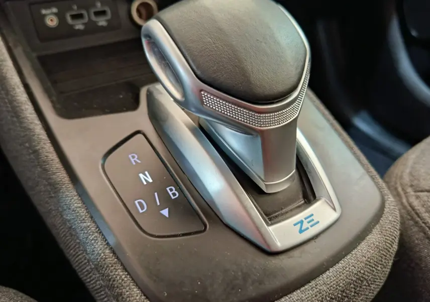 Gros plan sur la commande de boîte automatique de la Renault ZOE blanche, avec logo ZE bleu visible.