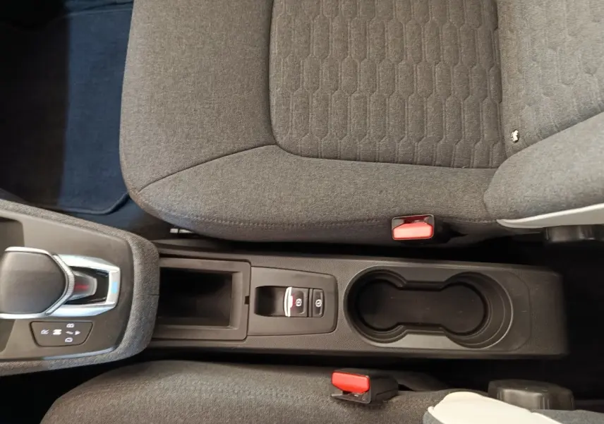 Vue plongeante sur la console centrale et sièges gris de la Renault ZOE Zen R135 blanche, avec levier de vitesse automatique.