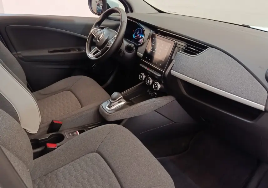 Intérieur de la Renault ZOE Zen 2021, vue côté conducteur, volant cuir, écran tactile central et sièges gris.