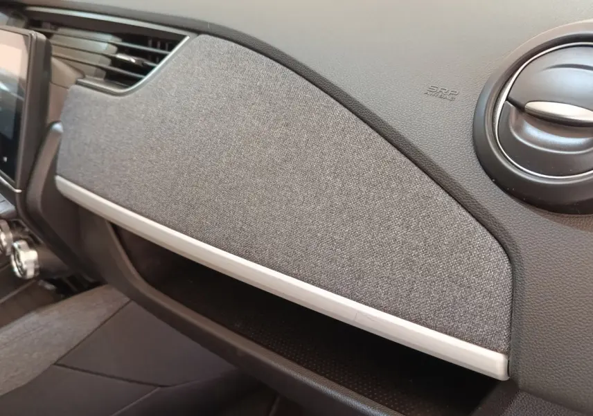 Vue rapprochée de la planche de bord grise et noire de la Renault ZOE Zen R135 2021, avec aérateur rond noir.