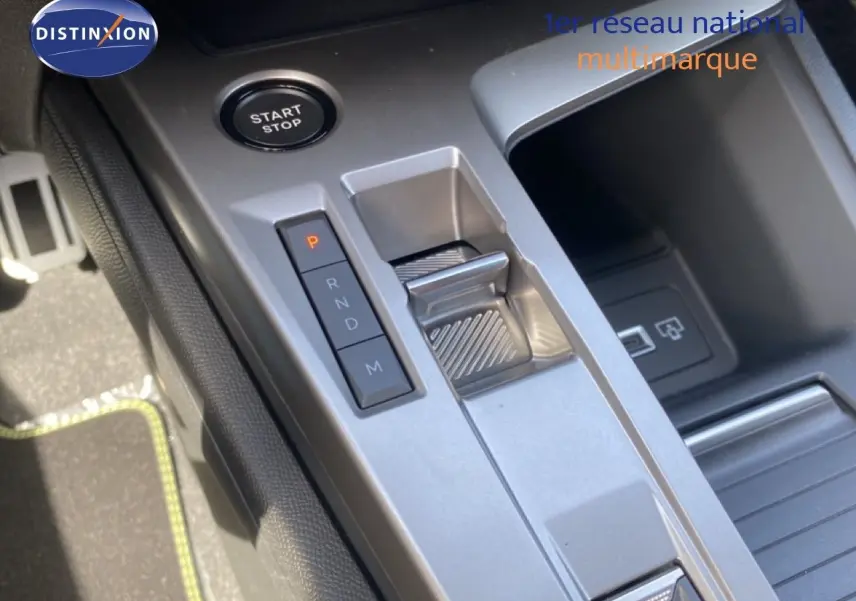 Gros plan sur la console centrale de la Peugeot 308 Hybrid 2026, avec la commande de boîte automatique et bouton start/stop.