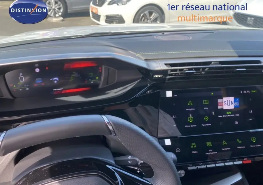 Vue intérieure centrée sur le tableau de bord et le volant d’une Peugeot 308 Hybrid 145ch GT, avec écran tactile allumé.