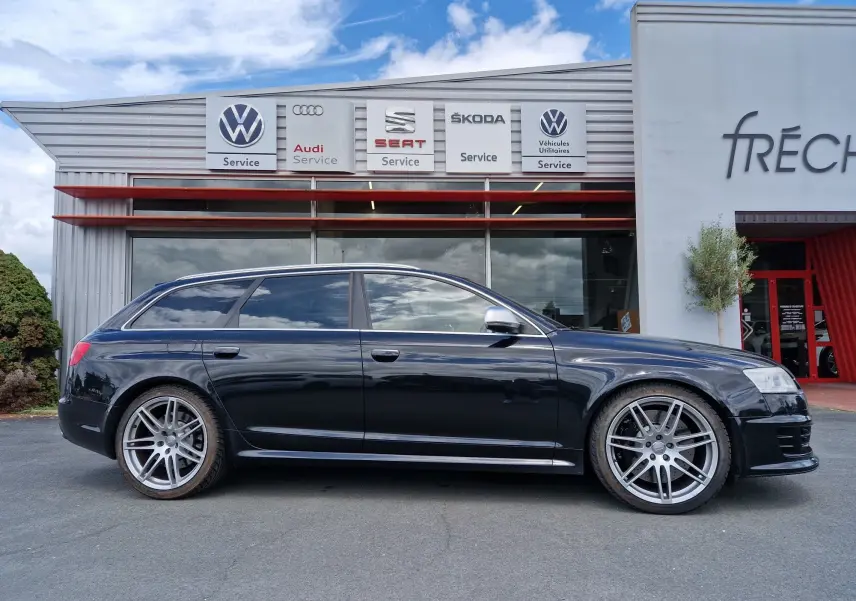 Audi RS6 Avant noir vue de profil côté gauche, soulignant ses jantes alliage sport et son design élégant.