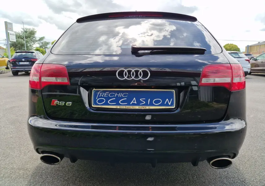 Vue arrière d’une Audi RS6 Avant noire de 2009 avec double sortie d’échappement et logo RS6 visible.