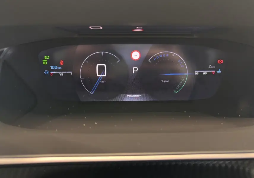 Vue rapprochée du combiné numérique 3D du Peugeot 2008 blanc, affichant vitesse, mode et jauges hybrides.